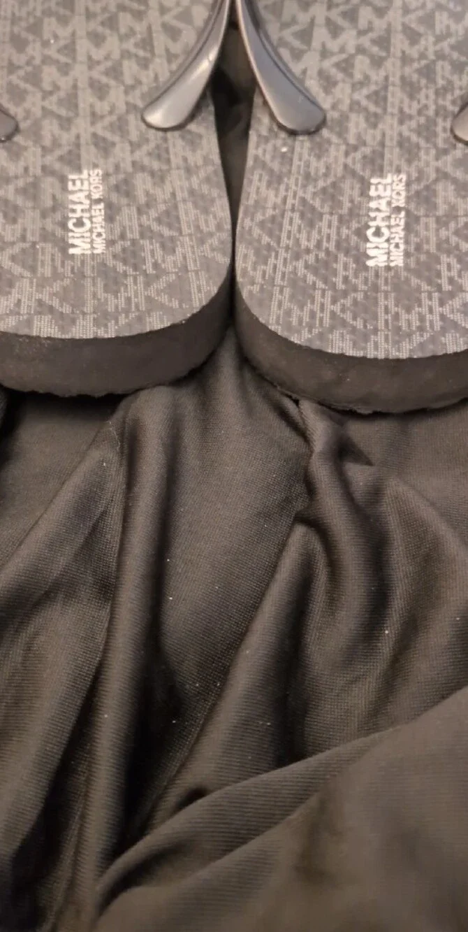 Michael Kors Black Logo Monogram Flip Flops with Silver MK Medallions.